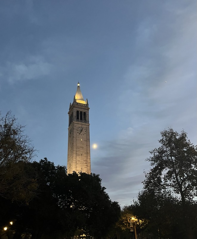The Berkeley Campanile at dusk with the moon behind it