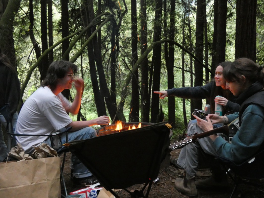 Friends around a campfire at Pomo Canyon with a guitar