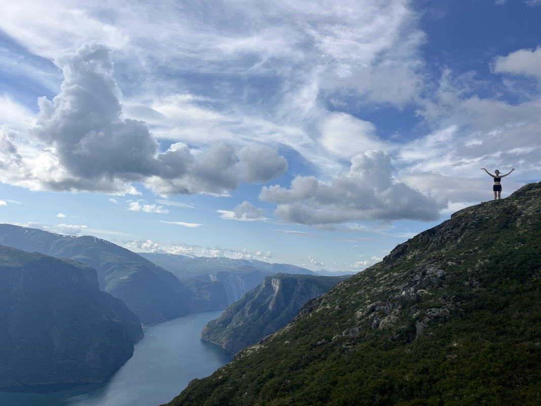 Standing with arms outstretched at the summit of Mt. Prest, high above a Norwegian fjord